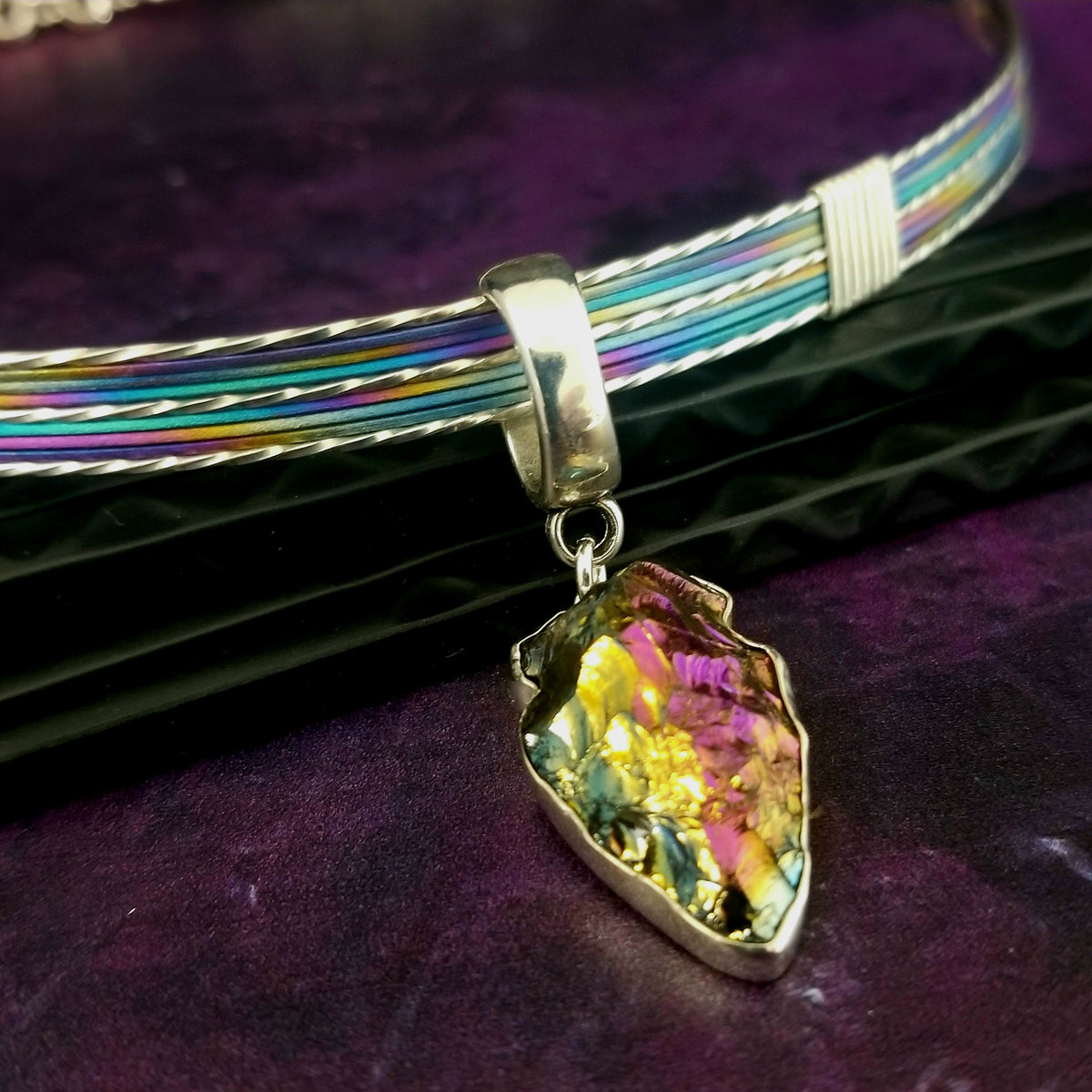 A silver necklace on a wood surface.