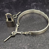 The Cadman Key Keeper Cuff features a chain with a detachable clasp that holds the key to the submissive's lock. With these unique jewelry clasps, the key chain removal is quick and convenient - the key chain can even be linked to a collar during play. Crafted from sterling silver, these luxurious pieces add a sophisticated flair to BDSM boudoirs. By My Secret Heart Studios