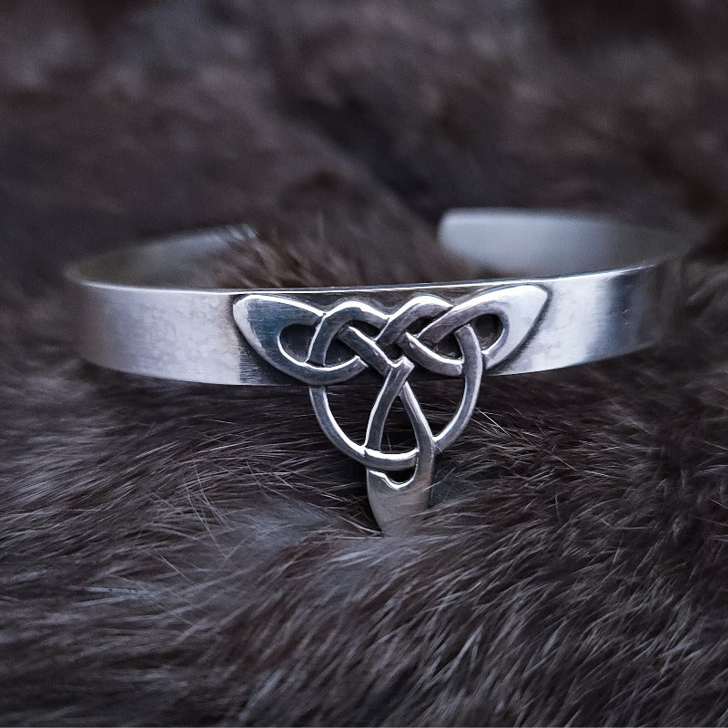 This traditional classic CELTIC DANCE cuff, adorned with a sterling Triquetra Knot, pays homage to the spirited nights of Celtic music and dancing. Its robust design ensures a lifetime of use, while the polished sterling silver offers a lustrous shine that never fades. This timeless piece of Celtic jewelry is sure to be a conversation starter.