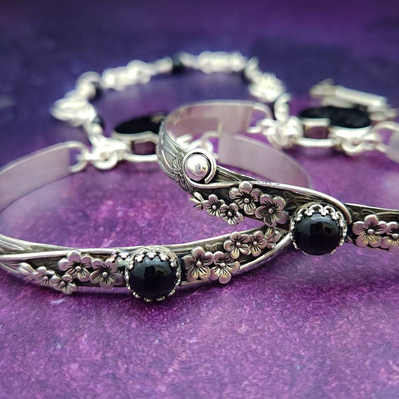 Adorn yourself with this beautiful handcrafted silver and onyx chain that can be transformed into stylish handcuffs and ankle restraints, a chic locking collar, or a decorative necklace for Dominants. Connect it to the back of a collar for a sexy look, and give a tug on the chain for an extra choking sensation. With its versatile appeal, CONVERSION CHAIN, BLACK ONYX & STERLING will certainly be a beloved accessory! By My Secret Heart Studios