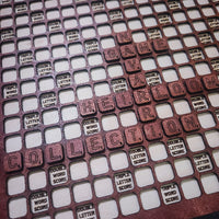 Scrabble tile holder with letter tiles and score indicators.