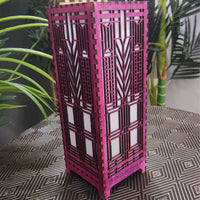 Amethyst decorative lamp with geometric patterns on a patterned surface with plants in the background