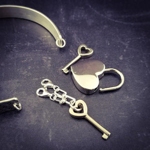 This substantial sterling silver Dominant's Key Cuff is created with a detachable chain that holds the key to Your slave or sub's locked collars or cuffs. Jewelry clasps clip into rings that attach to the cuff, which makes removing the chain simple. You can even attach it to Your slave's collar during play for safe keeping.