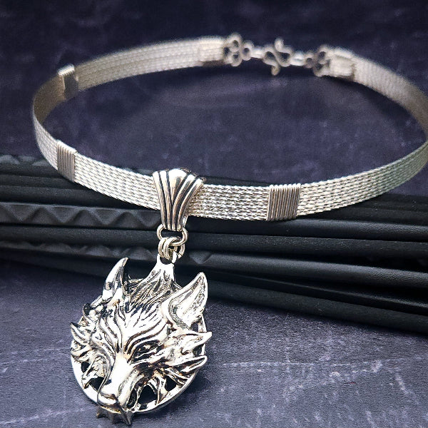 This wire wrapped artisan collar is hand crafted in strands of twisted sterling silver and a wolf medallion from Final Fantasy VII has been added as a pendant