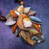 FOREST FAIRY SIENNA is a one-of-a-kind artisan Necklace. A sweet little fairy is caught napping in her nest of leaves. Each is a one-of-a-kind piece of wearable art with its own unique look and personality.  By Studio Navarri