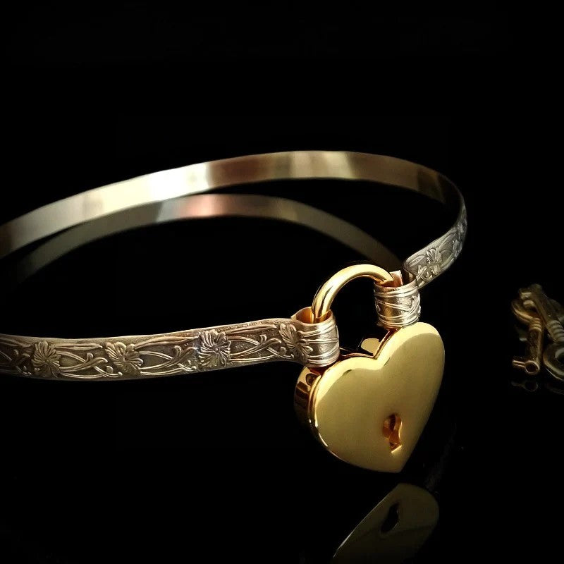 Our Soft and Sweet submissive collar is the epitome of feminine grace. Handcrafted with loving care, this artisan-made 14k gold filled submissive collar radiates femininity with its floral sterling silver pattern and a hand-set 8mm pink sapphire. Beautifully feminine and romantic.  DISCREET FOR DAYTIME For discreet day wear, use the handcrafted 'day clasp'. LOCKING FOR PLAYTIME The jewelry locked with the padlock, transforming it from a traditional jewelry design into unique and stunning submissive jewelry.