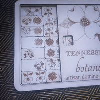 Floral dominoes game set with 'Tennessee Botanicals' branding on a textured surface.