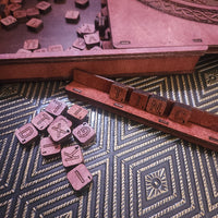 Wooden scrabble blocks on stand on a patterned surface
