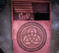 Wooden scrabble box with a Celtic knot design on a patterned surface