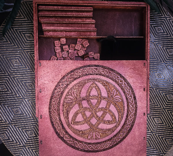 Wooden scrabble box with a Celtic knot design on a patterned surface