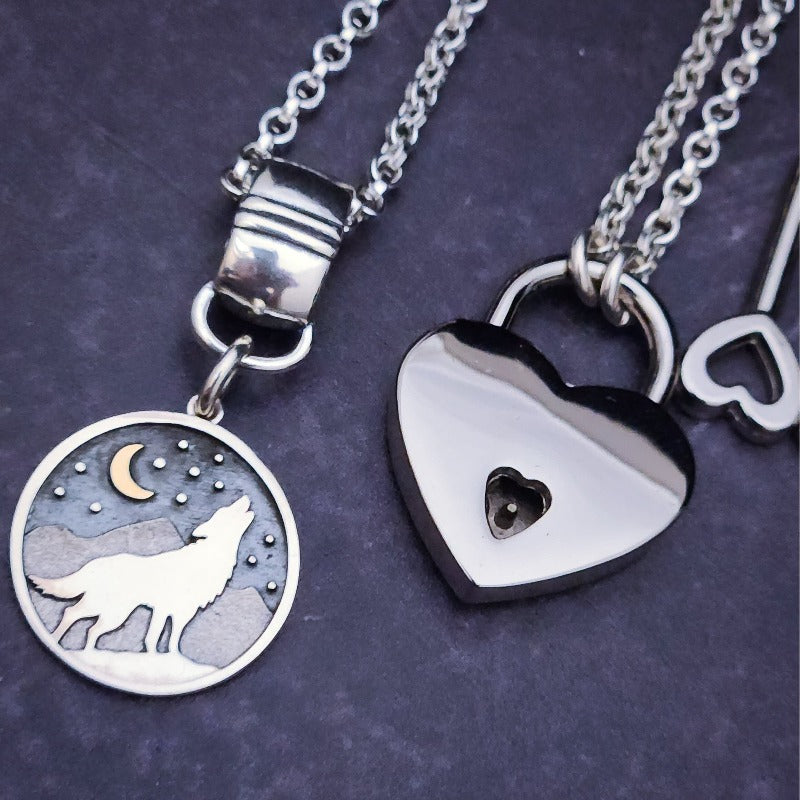This Wolf Necklace can also be used as a collar slide to make a bold statement piece of Ownership. With a silhouette of a wolf howling in front of a crescent moon, against ablack starry sky and mountains, all sterling. The slide can easily be removed from the chain, and is compatible with *most* submissive collars. My Secret Heart Studios