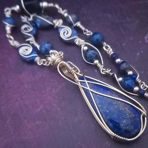 DEEP BLUE like midnight skies and ocean depths.  This asymmetrical collar necklace is a testament to artisan craftsmanship and design. The Lapis Lazuli Cabochon is encased in a Wire Wrapped setting with a beautifully fluid look, And the gemstones are embellished with sterling silver adding a unique look.