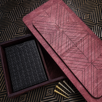 Inside top of Teak stained Cribbage Box with geometric pattern on a matching box, open to reveal a black cardholder and gold pegs.