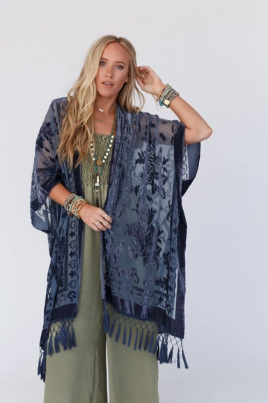 Get ready to turn heads in this chic kimono! The luxurious velvet and mesh combo is sure to make a statement and the playful tassels add a touch of flirty fun. Pair it with your go-to basics for an effortlessly stylish ensemble!