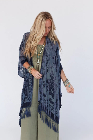 Get ready to turn heads in this chic kimono! The luxurious velvet and mesh combo is sure to make a statement and the playful tassels add a touch of flirty fun. Pair it with your go-to basics for an effortlessly stylish ensemble!