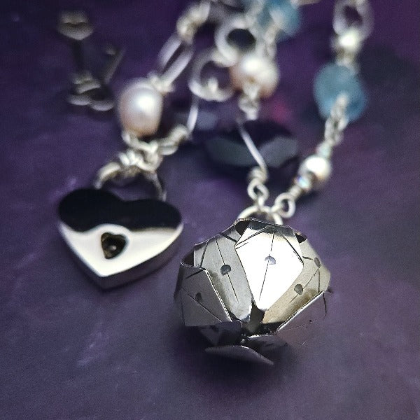  Crafted with My Secret Heart's signature grace and discretion, our locking submissive kitten bell is a one-of-a-kind design. Embellished with dazzling sterling silver, Aquamarine nuggets, Amethyst gems, and Freshwater Pearls, this exquisite and eye-catching collar will make your kitten stand out! 