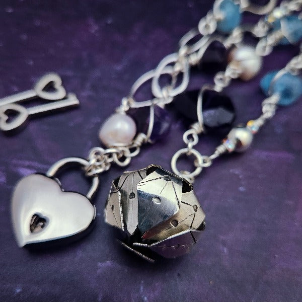  Crafted with My Secret Heart's signature grace and discretion, our locking submissive kitten bell is a one-of-a-kind design. Embellished with dazzling sterling silver, Aquamarine nuggets, Amethyst gems, and Freshwater Pearls, this exquisite and eye-catching collar will make your kitten stand out! 