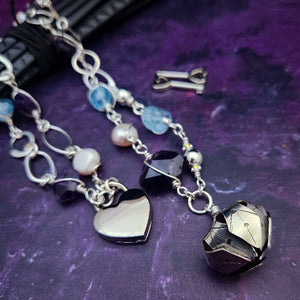 Crafted with My Secret Heart's signature grace and discretion, our locking submissive kitten bell is a one-of-a-kind design. Embellished with dazzling sterling silver, Aquamarine nuggets, Amethyst gems, and Freshwater Pearls, this exquisite and eye-catching collar will make your kitten stand out! 