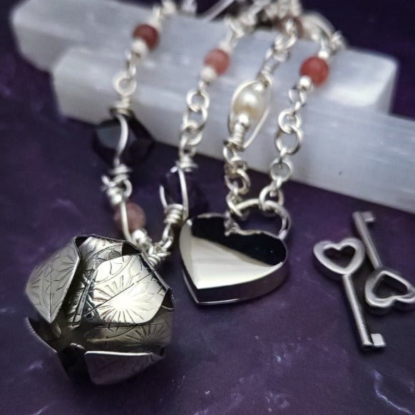 An original, one of a kind design, our locking submissive kitten bell is handcrafted with all the grace and discretion that My Secret Heart is known for. Wear this as a fashion piece or as a subtle submissive or pet play collar, either way you will look amazing!  Crafted in luxurious sterling silver and embellished with pretty pink Rhodochrosite, Amethyst nuggets, pearls and stardust beads, this will make your kitten feel so pretty!  By My Secret Heart Studios