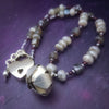 Rich Moonstone, Labradorite and Ruby glisten to give this piece a look of luxury, guaranteed to make your kitten purr with delight! An original, one of a kind design, our locking submissive kitten bell is handcrafted with all the grace and discretion that My Secret Heart is known for. Wear this as a fashion piece or as a subtle submissive or pet play collar, either way you will look amazing! 