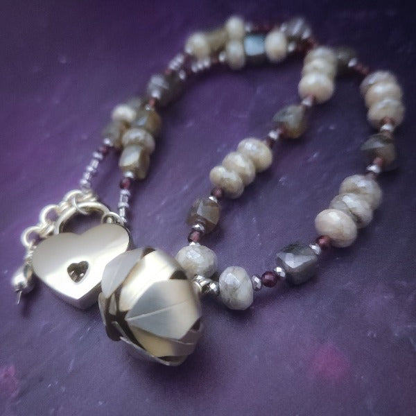 Rich Moonstone, Labradorite and Ruby glisten to give this piece a look of luxury, guaranteed to make your kitten purr with delight! An original, one of a kind design, our locking submissive kitten bell is handcrafted with all the grace and discretion that My Secret Heart is known for. Wear this as a fashion piece or as a subtle submissive or pet play collar, either way you will look amazing! 