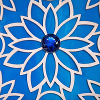 Decorative tile with blue floral design and central gemstone on a blue background