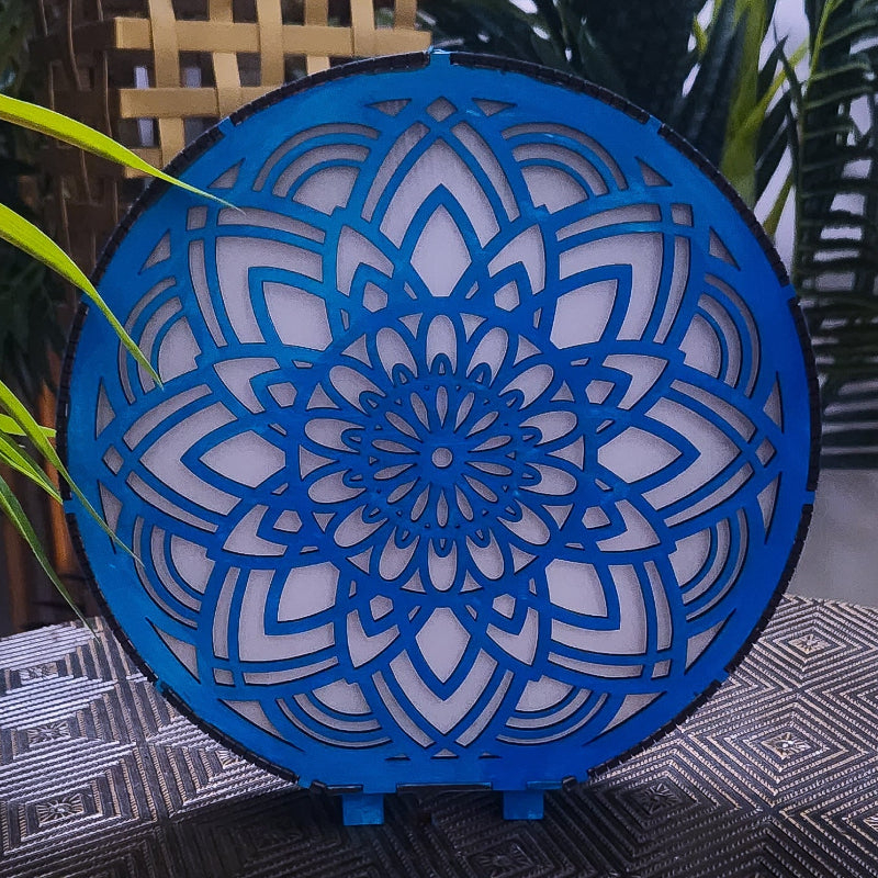 Decorative blue and white circular lamp with intricate patterns on a textured surface.