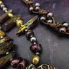 Make a bold statement with MARNIA, the one-of-a-kind necklace featuring titanium druzy, freshwater pearls, and a handcrafted bronze medallion ammonite. Turn heads with the vibrant colors and asymmetrical design, guaranteed to make you look and feel unforgettable!