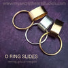 Gold and silver O ring slides on a purple background with website text.