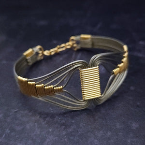 A modern twist on classic royalty, the CLEO Locking Cuff Bracelet is a bold yet discreet tribute to the powerful Egyptian Queen. Wrapped in titanium and accented with 14K gold filled details, it's an alluring and timeless statement piece.A modern twist on classic royalty, the CLEO Locking Cuff Bracelet is a bold yet discreet tribute to the powerful Egyptian Queen. Wrapped in titanium and accented with 14K gold filled details, it's an alluring and timeless statement piece.
