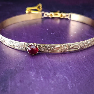 Our Soft and Sweet submissive collar is the epitome of feminine grace. Handcrafted with loving care, this artisan-made 14k gold filled submissive collar radiates femininity with its floral sterling silver pattern and a hand-set 8mm Garnet. Beautifully feminine and romantic.