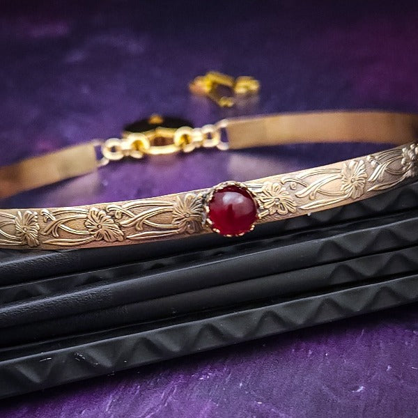Our Soft and Sweet submissive collar is the epitome of feminine grace. Handcrafted with loving care, this artisan-made 14k gold filled submissive collar radiates femininity with its floral sterling silver pattern and a hand-set 8mm Garnet. Beautifully feminine and romantic.