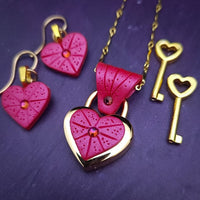 Revamp your locks with a touch of style. This locking soft chain collars features a small heart lock, adorned with a vibrant pink burst pattern and a sparkling center crystal. The embellished lock can also be worn with other collars and chains. Strut your ownership/submission in style ... never wear a plain ole' lock again!!
