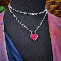 Revamp your locks with a touch of style. This locking soft chain collars features a small heart lock, adorned with a vibrant pink burst pattern and a sparkling center crystal. The embellished lock can also be worn with other collars and chains. Strut your ownership/submission in style ... never wear a plain ole' lock again!!