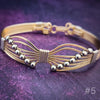 Artisan wire wrapped bracelet is created with precious metals. Hand sculpted into soft wings and embellished with strategically placed beads to form a fluttering butterfly. By My Secret Heart Studios
