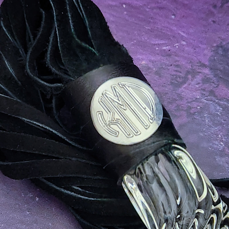 Experience the perfect balance of pleasure and pain with this BDSM Flogger in Black Leather and Glass! Stylish, luxurious, and crafted with great care, it's the classic impact toy of your kinky dreams. Personalize to your heart's content - heat it up or hit it hard - and explore a range of sensations with S&M play! Can be Monogrammed / Engraved. By My Secret Heart Studios