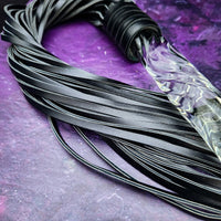 Experience the perfect balance of pleasure and pain with this BDSM Flogger in Black Leather and Glass! Stylish, luxurious, and crafted with great care, it's the classic impact toy of your kinky dreams. Personalize to your heart's content - heat it up or hit it hard - and explore a range of sensations with S&M play! Can be Monogrammed / Engraved. By My Secret Heart Studios