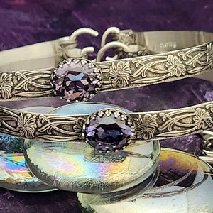 These artisan submissive BDSM handcuff bracelets are hand crafted in a classic floral pattern of sterling silver with faceted Amethyst gemstones.