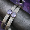 These artisan submissive BDSM handcuff bracelets are hand crafted in a classic floral pattern of sterling silver with faceted Amethyst gemstones.