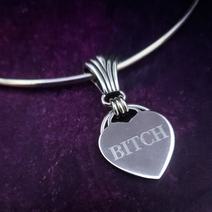 Even a Princess can be a Bitch. A sexy bracelet to celebrate submission. There is a solid HIDDEN O RING behind the heart which can accommodate a leash or be used as a connection point. The PRINCESS SLIDE can be removed and worn on most of our submissive collars, as well as worn on a chain as a pendant. Wear it locked with the small heart lock, or the stainless steel push clasp for discretion. {All included}