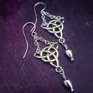 Recalling nights of Celtic music and spirited dancing, these CELTIC DANCE Triquetra Knot earrings are adorned with sterling chain and a tapered bead and are reminiscent of traditions past, present, and future. Meticulously handcrafted ear wires ensure years of enjoyment. By My Secret Heart Studios