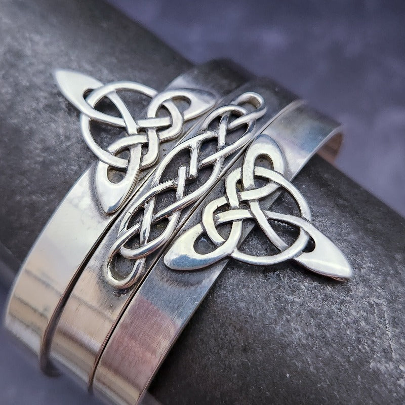 This traditional classic CELTIC DANCE cuff, adorned with a sterling Triquetra Knot, pays homage to the spirited nights of Celtic music and dancing. Its robust design ensures a lifetime of use, while the polished sterling silver offers a lustrous shine that never fades. This timeless piece of Celtic jewelry is sure to be a conversation starter.