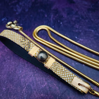 Luxurious BDSM leash for that special time or event. The Golden Snakeskin Leather is accented gold wire wraps and features an earthy toned natural Pyrite gemstone. Riveted for strength. The 35 inch golden brass snake chain is slinky with a sensual feel.  A swivel trigger clip moves with you both for great mobility. This is uber-sexy! My Secret Heart Studios