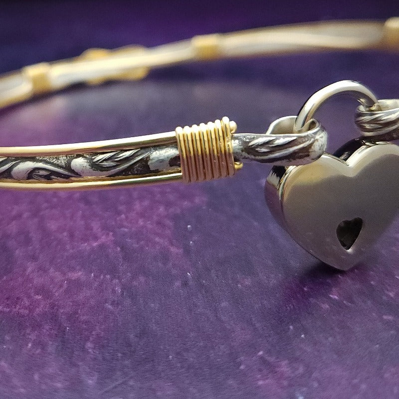 Symbolizes eternity, empowerment, and everlasting love.  A silver floral pattern is surrounded and accented with 14K gold fill wire. The focal lover's knot is a timeless expression, signifying two people have become one, bound together by their love. By My Secret Heart Studios