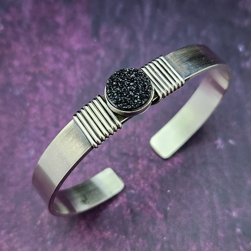 The substantial weight of The Simplicity sterling cuff lends this a sense of gravitas, while a powerful black druzy is embraced by sterling silver wraps. The simplistic design makes it a perfect companion for almost any other jewelry in your collection.  Goes beautifully with our Celtic Inspired Cuffs. By My Secret Heart Studios