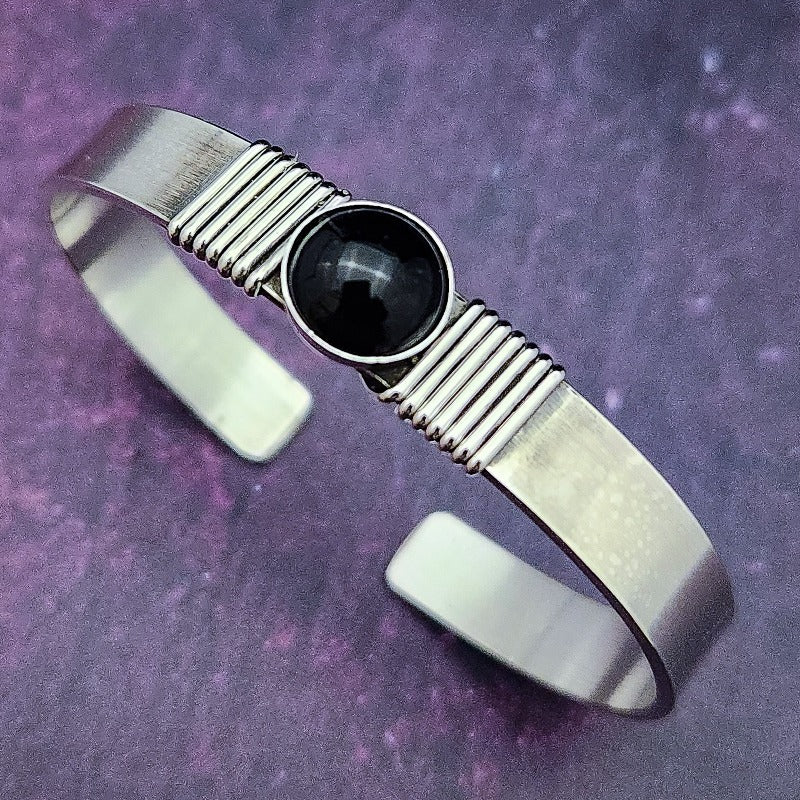 The substantial weight of this sterling cuff lends this a sense of gravitas, while a timeless black onyx is embraced by sterling silver wraps. The simplistic design makes it a perfect companion for almost any other jewelry in your collection.  Goes beautifully with our other Celtic Inspired By My Secret Heart Studios
