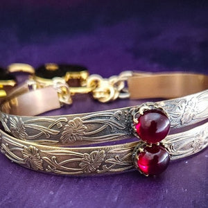 Show your ownership or submission with style and grace. Our best selling ‘SOFT and SWEET’ Locking BDSM submissive handcuff bracelets are now available in anklets sizes as well. These artisan handcuffs / ankle restraints are hand crafted in a pretty feminine floral pattern of 14kGold-Fille and natural Garnet. The epitome of feminine grace. 