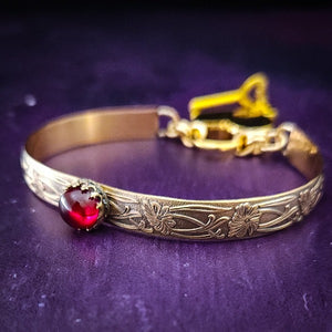 Show your ownership or submission with style and grace. Our best selling ‘SOFT and SWEET’ Locking BDSM submissive handcuff bracelets are now available in anklets sizes as well. These artisan handcuffs / ankle restraints are hand crafted in a pretty feminine floral pattern of 14kGold-Fille and natural Garnet. The epitome of feminine grace. 