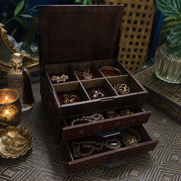 Wooden jewelry box with jewelry on a patterned surface