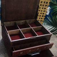 Wooden jewelry box with compartments on a patterned surface